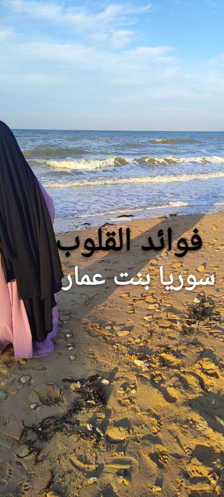 Une femme en jilbab noir et robe mauve marche sur une plage au coucher du soleil, regardant la mer. Le ciel est légèrement nuageux, les vagues douces. Elle incarne la sérénité et l’attente d’un amour sacré.
